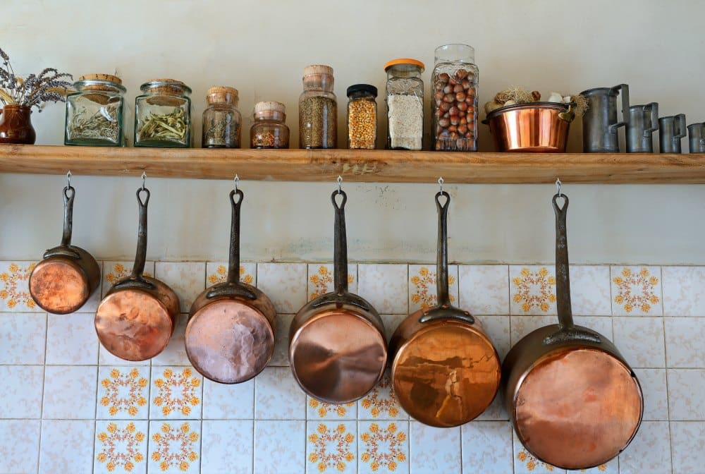 Old saucepans hanging from in a traditional-style kitchen